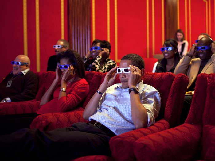 People watching a movie at the White House, where the theater seat dimensions allow for four seats in the front row
