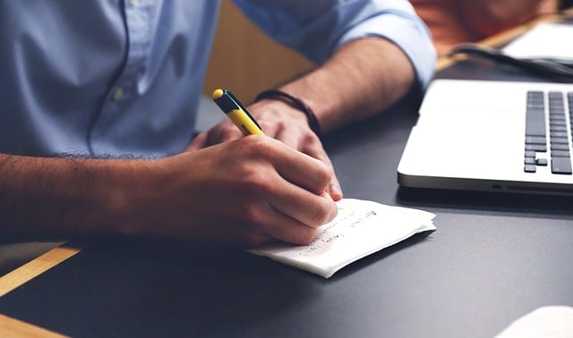 man writing notes