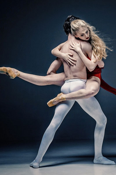 ballet dancers holding each other red dress