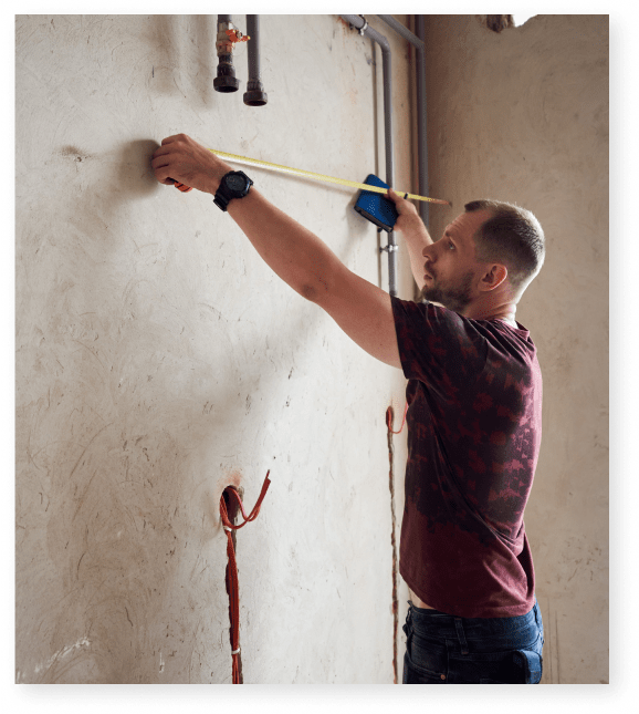 contractor measuring wall