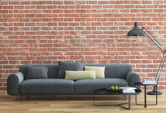 large grey couch with brick wall