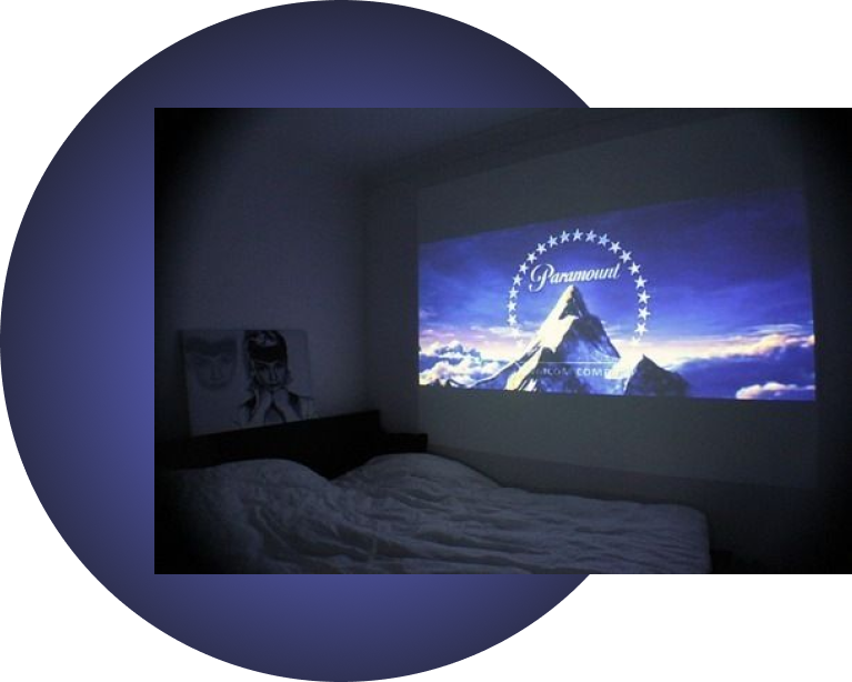 Movie display projected on a white wall in a bedroom facing the bed